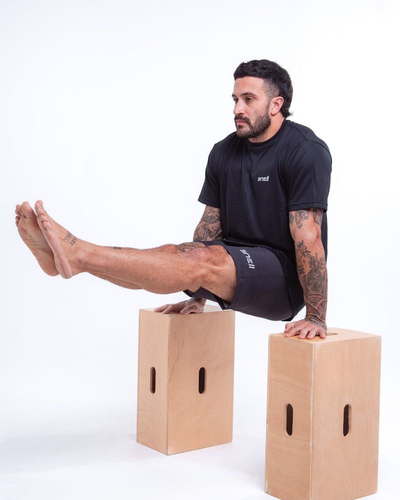 Man performing controlled strength exercise in a dark gym